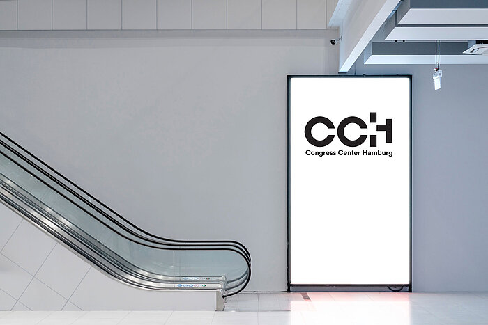 CCH Signage & Branding Rolltreppe daneben Stele mit CCH-Logo